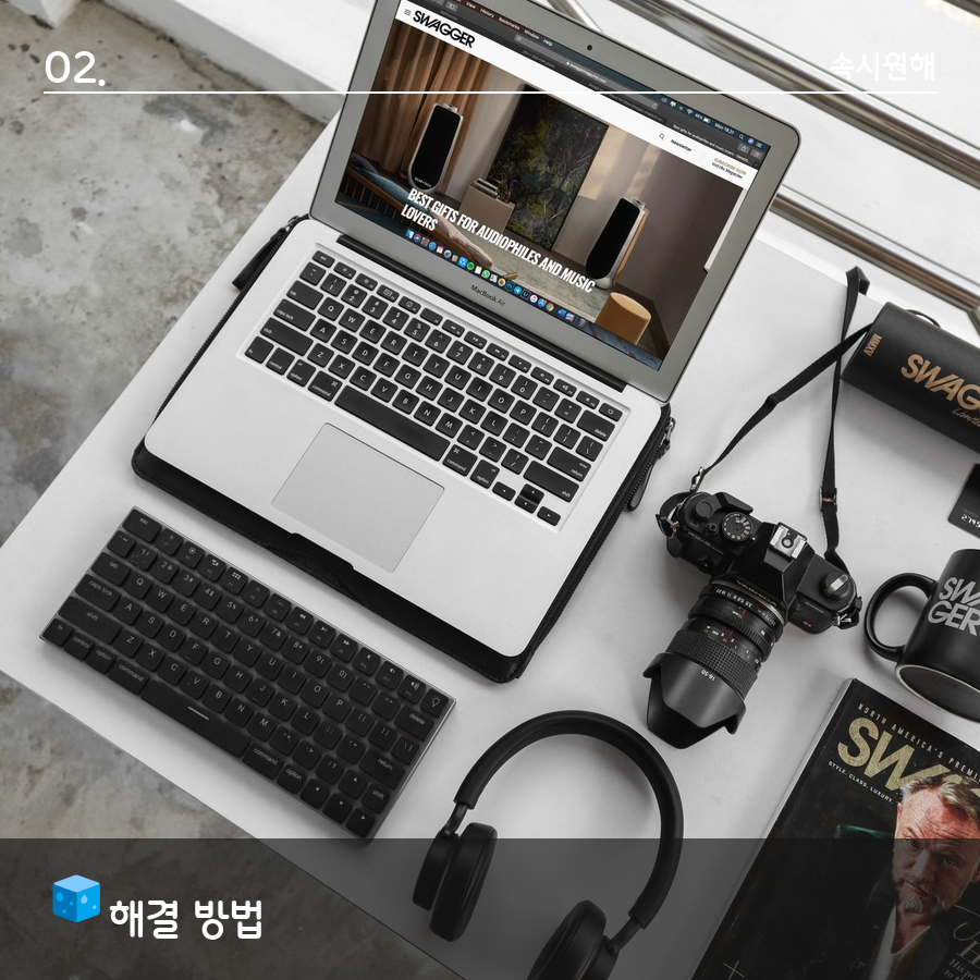 흰 책상 위에 노트북과 키보드, 카메라, 헤드폰이 놓인 흑백 톤 사진, '해결 방법' 섹션 이미지