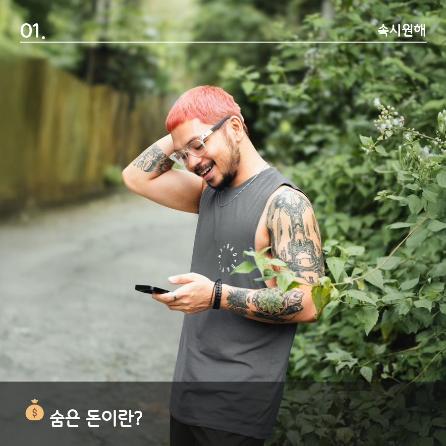 나무 울타리 옆 길에서 스마트폰을 보며 웃는 남성, '숨은 돈이란?' 섹션 이미지