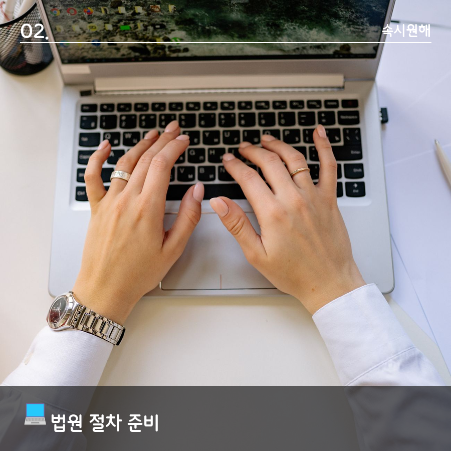 노트북 자판을 두드리며 법원 절차를 준비하는 손
